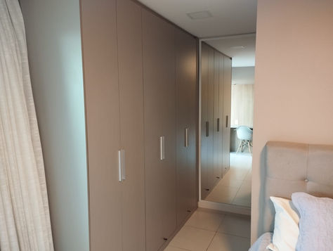 Suíte master e closet de apartamento de luxo com vista panorâmica para o mar no Porto das Dunas