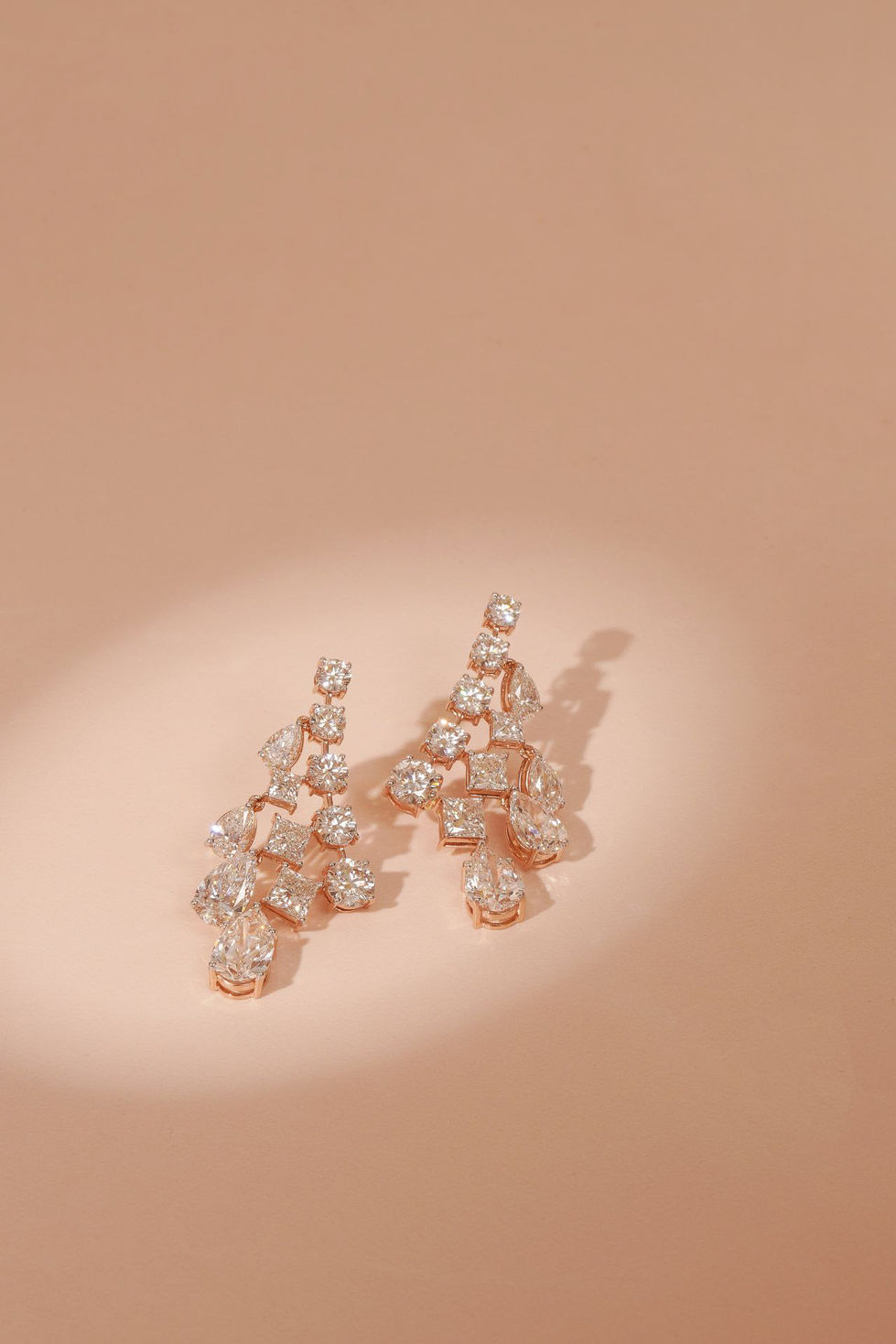 Elegant crystal earrings on a soft beige background.