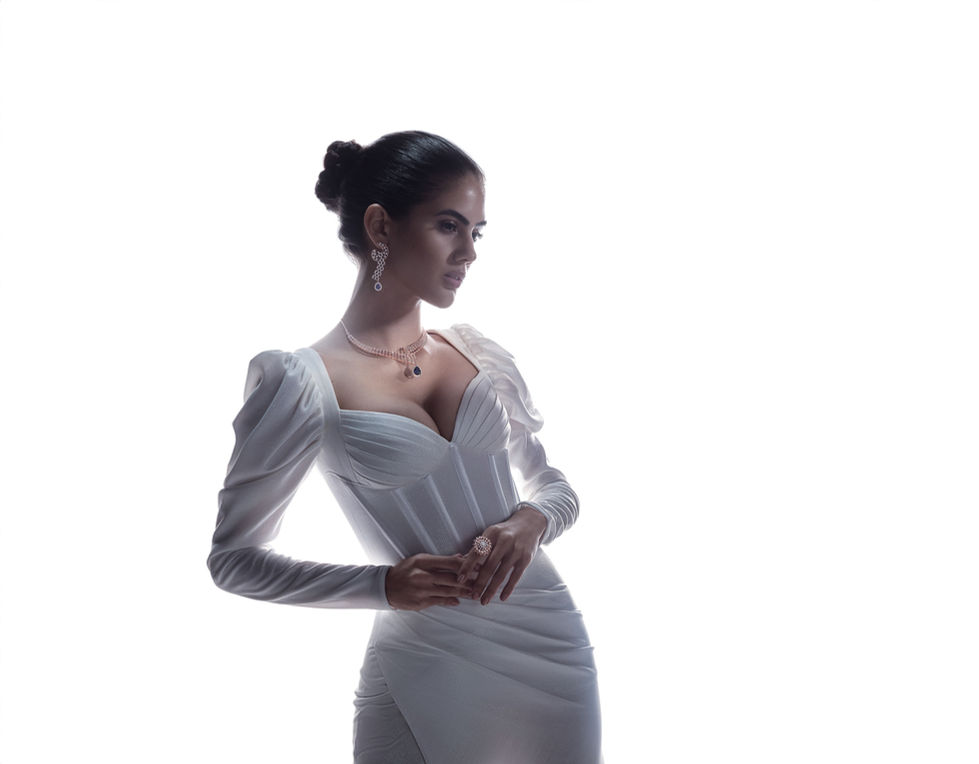 Elegant woman in white dress, posed gracefully.