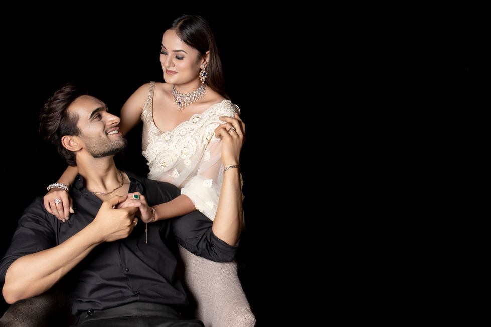 Couple posing elegantly against a black background.