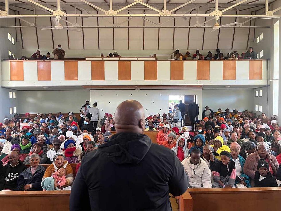 A speaker addressing a large congregation during missions.