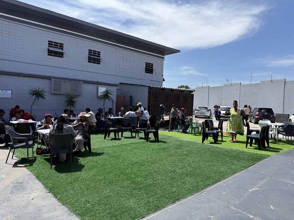 People gathering outdoors for community missions on grass.