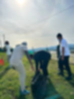 Volunteers on community missions picking up trash outdoors.