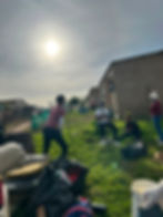 Volunteers on community missions outdoors near houses.