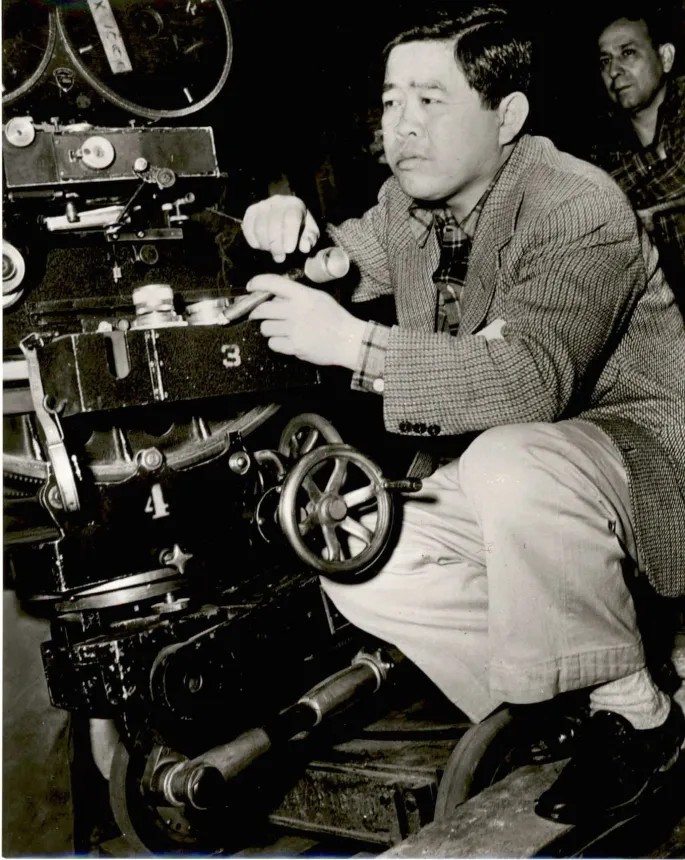 James Wong Howe sitting behind a movie camera