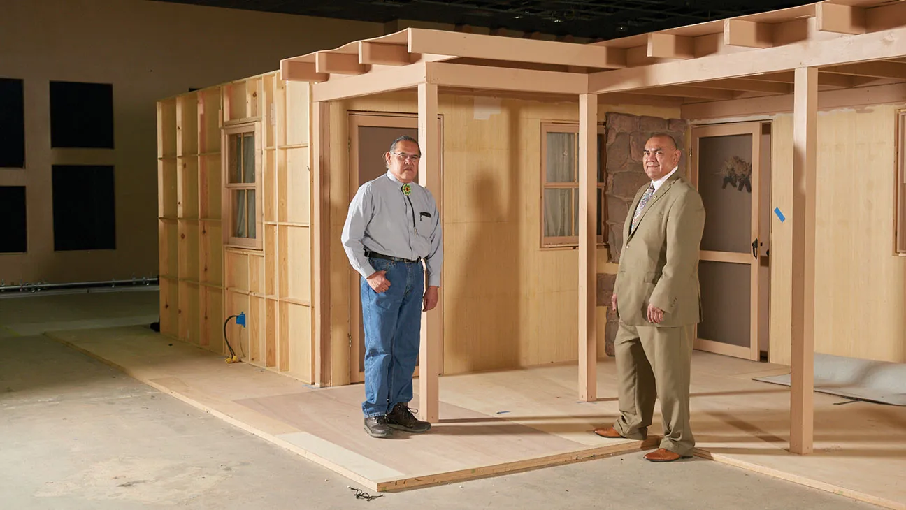 Two men stand in front of a construction build-out