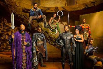 Four black men and four black women dressed in colorful draped like garb and armor. They appear to be in a cave and from a fantasy land. 