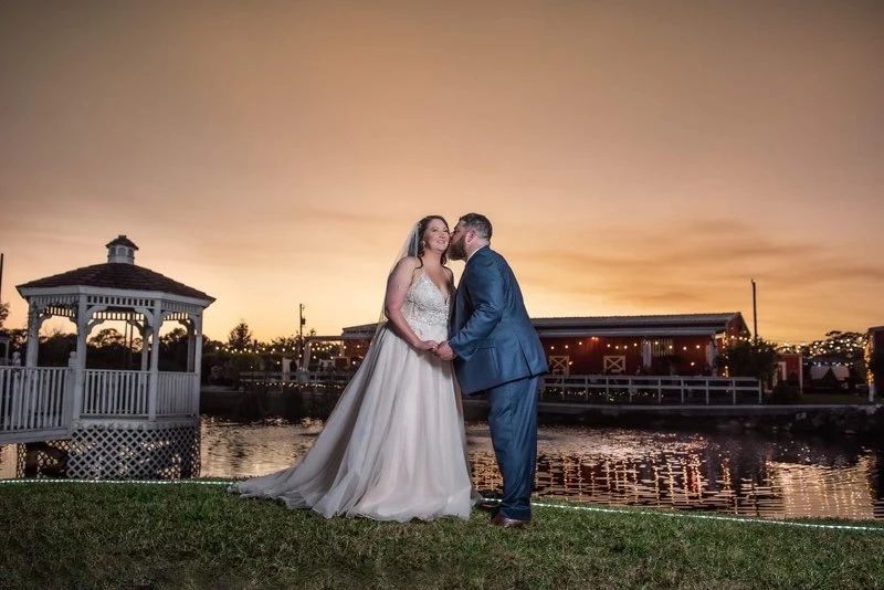 Bridal couple with barn and water view