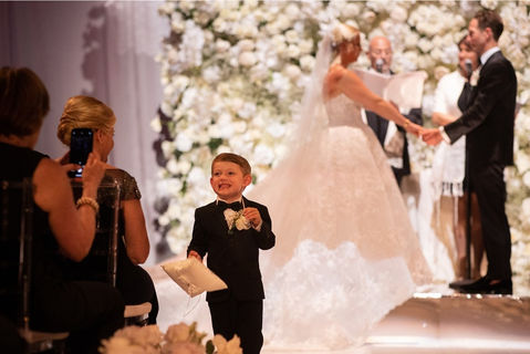 a young ring bearer smiling at a co-officiated wedding in New York City, New York