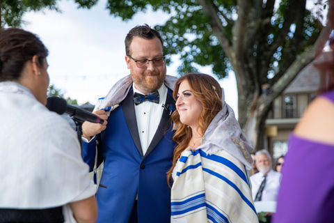 a bride and groom wrapped in a Tallit at their Jewish wedding at The Connecticut Shoreline