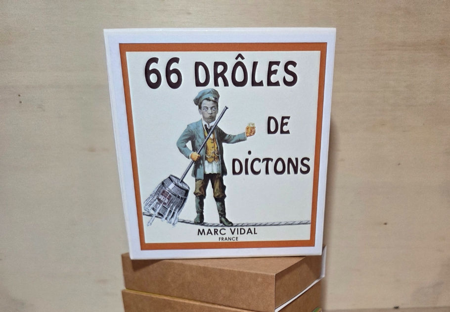 Boites carrée posée sur plusieurs boites en carton sur laquelle il est noté 66 drôles de dictons