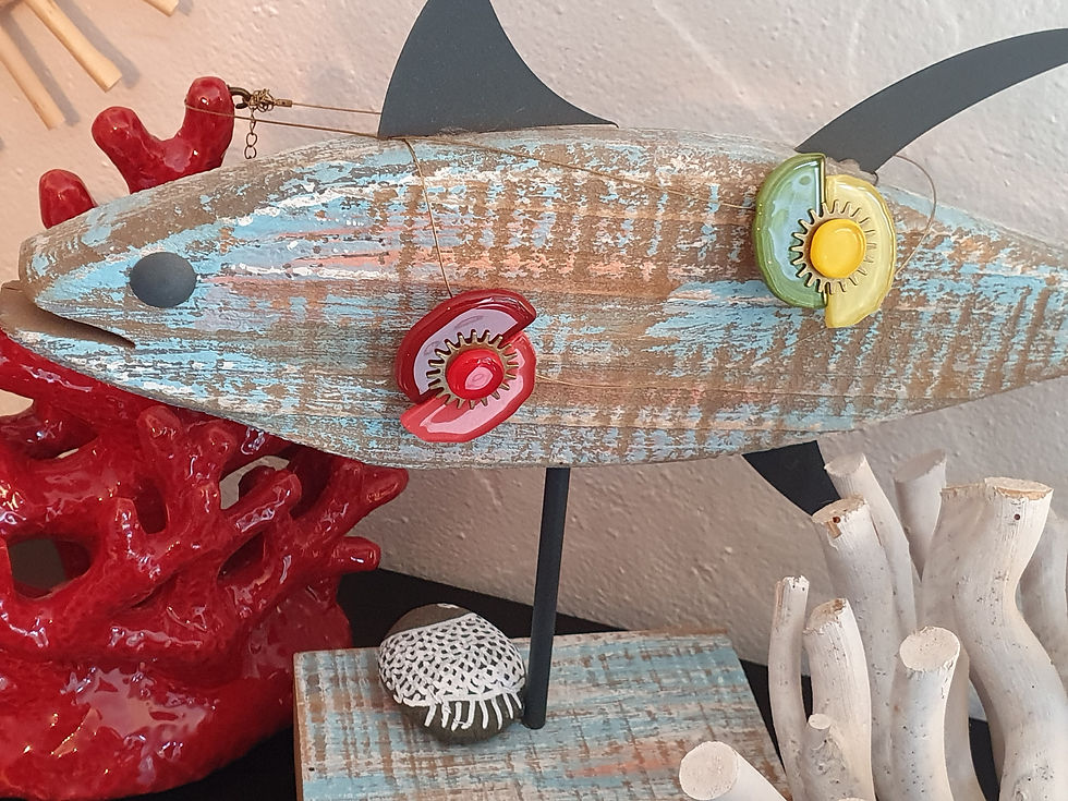 Miniature : collier en verre posé sur un poisson sculpté en bois bleu