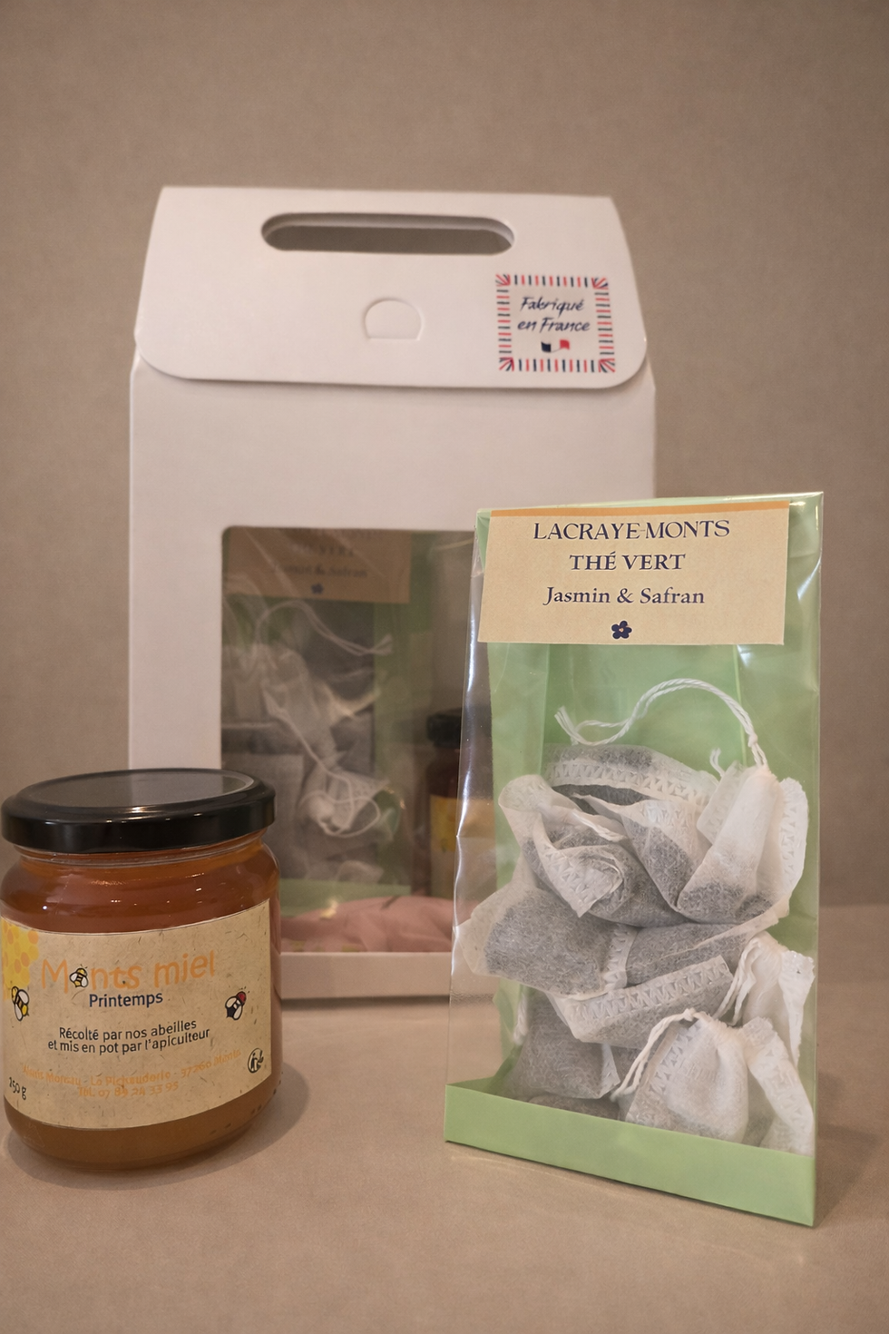 Un pot de miel de printemps , un sachet d infusetets de thé vert jasmin safran et un coffret cadeau blanc
