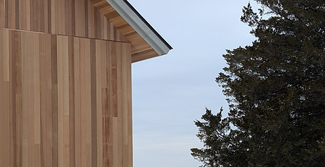 Vertical cedar siding on new cottage with Hudson Valley in background