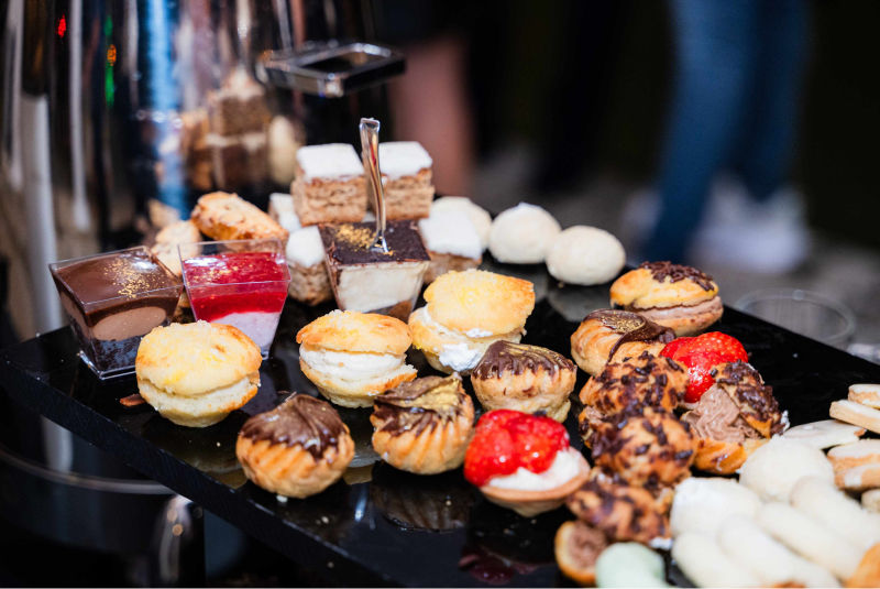 Modern glatt kosher dessert bar setup for a Bat Mitzvah in Miami Beach – pareve mousse, fruit pavlova, and chocolate donuts.