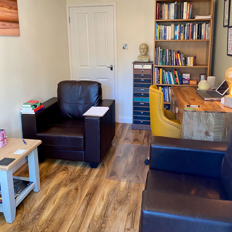 Private consultation room with chairs, tables, laptop, bookshelf and drawers and at IamPsychiatry in Luton