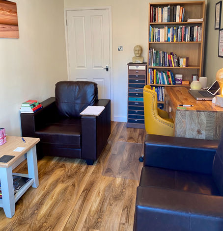 Private consultation room with chairs, tables, laptop, bookshelf and drawers and at IamPsychiatry in Luton