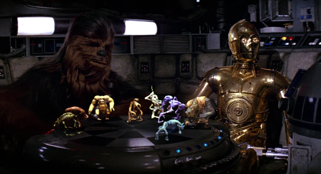 C-3PO and Chewbacca sit around a table playing Dejarik, a chess-like game.