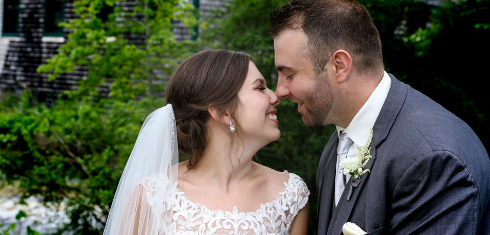 Candid moment for the bride and groom at Jones River Trading Post in Kingston MA as they giggle between shots out behind the main building by the water at Jones River Trading Post in Kingston MA