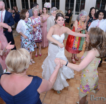 Bride surrounded by guests and friends on the dance floor at her wedding at Granite Links in Quincy MA
