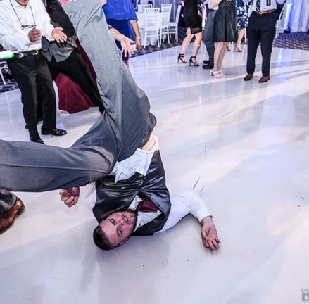groomsman upside down breakdancing on the white floor of Avenir in Walpole during a wedding.
