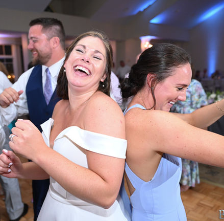 Bride laughing and dancing with her friends at her wedding at Granite Links in Quincy MA