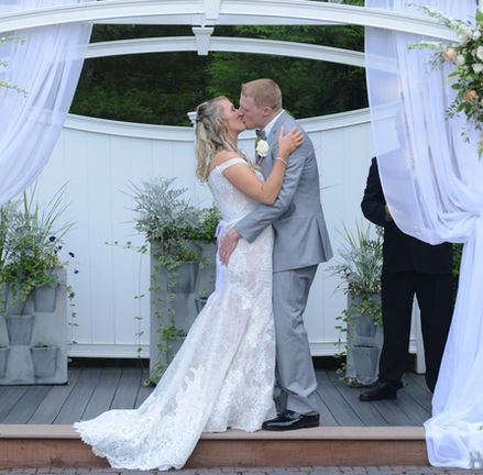 The outdoor ceremony pergola at Miraval Gardens in East Bridgewater MA all dressed up with white linens and floral arrangements for a spring ceremony.