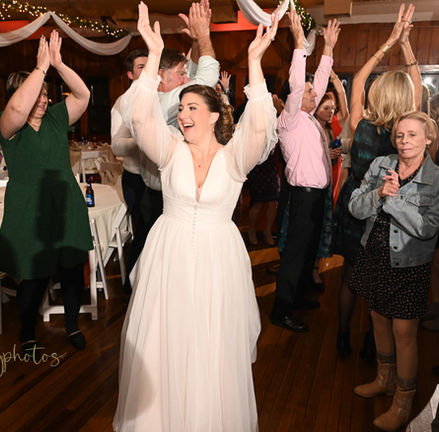 Bride raising her hands in celebration at her wedding at Camp Kiwanee in Hanson MA