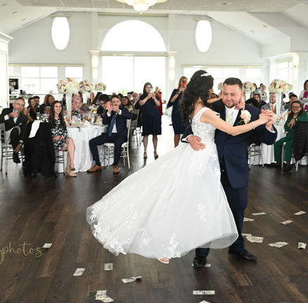 Bride lifted off the dance floor and spun by groom during their first dance on the dance floor inside the ballroom of Granite Links in Quincy MA