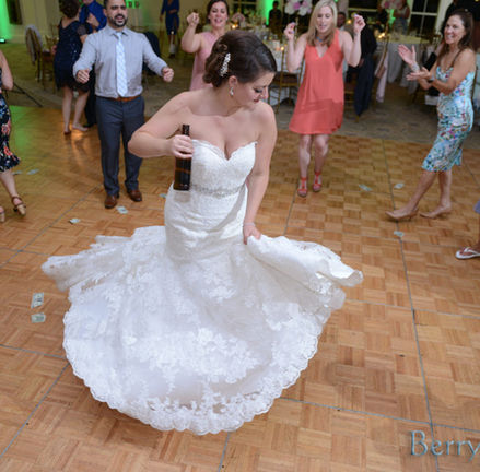 Guests look on as this bride spins her dress on the dance floor of her wedding at Granite Links in Quincy MA