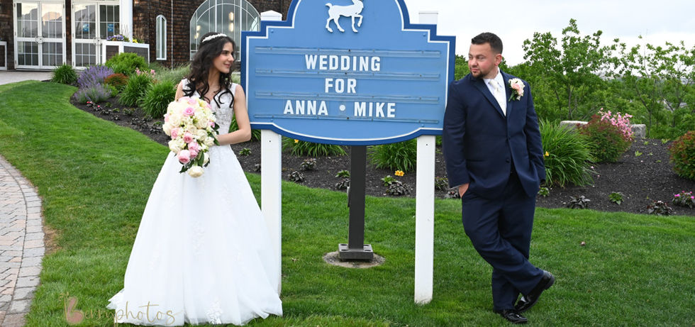 Bride and groom casually hanging out by the wedding sign with their names on it at Granite Links in Quincy MA