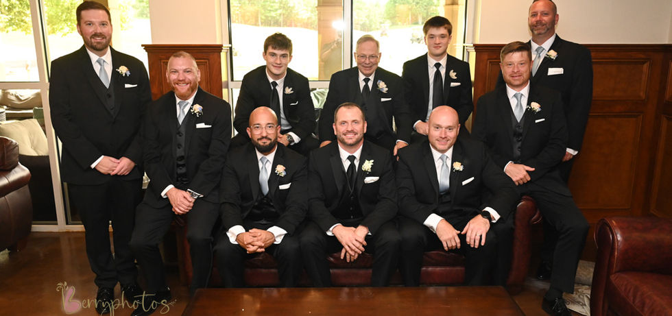 Groomsmen surround the groom on the leather couch of Indian Pond Country Club's lower level where wood paneled walls and cherry wood furniture creates a masculine vibe.