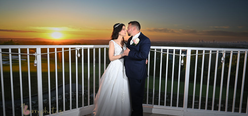 Bride and groom lit with perfect level of off-camera flash as they stand on the back deck of Granite Links in Quincy retaining all the deep rich colors of the perfect sunset behind them.
