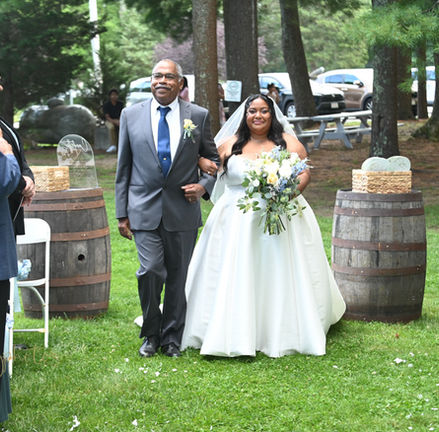 bride and her dad are walking down the aisle at Loon Pond Lodge in Lakeville MA with guests standing on either side in support.