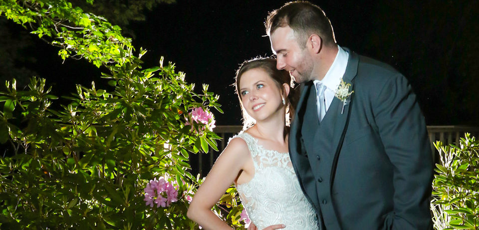 Bride and groom are lit with several flashes for this night photography shot at Jones River Trading Post in Kingston MA