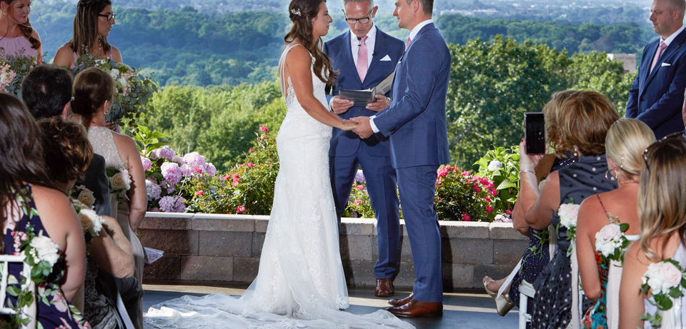 I dare you to find another photographer that can get this kind of shot.  The couple and their guests are inside the tent but I retained all the detail of the rolling hills and city skyline behind them.  That city is 9 miles away and I got it perfectly.  Doing so would naturally silhouette the couple and their guests, so I lit them all with a few off-camera flashes so I can have them perfectly lit while retaining the city skyline.  After all, the chose this venue for that view, so it absolutely needs to be visible in their ceremony pictures and only I can do that in this region.  