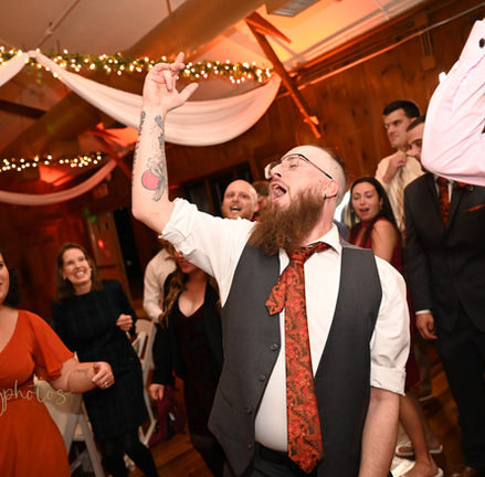 Groomsman gettign down to a deep beat while dancing on the dance floor at a Camp Kiwanee in Hanson MA wedding.
