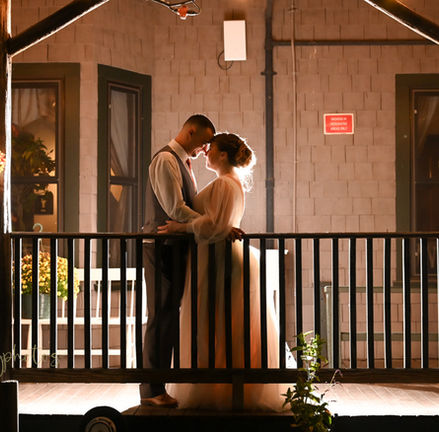 Bride and groom are on the front porch of Camp Kiwanee in Hanson MA on a rainy wedding day at Camp Kiwanee in Hanson MA