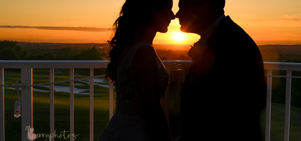 couple silhouetted in front of a blazing orange sunset at Granite Links in Quincy MA