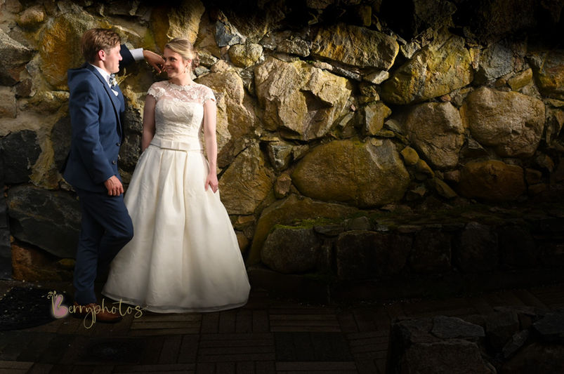 This Cape Cod wedding was at an art gallery in Yarmouth MA and shows a couple with dramatic artistic lighting on them against a stone wall at their art gallery.