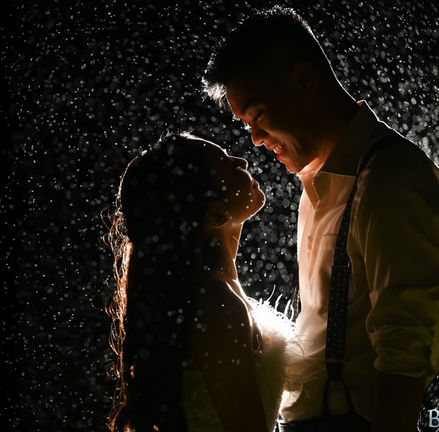 A single flash lights the bride and groom from behind to give them some rim light while also lighting up every drop of rain at Camp Kiwanee in Hanson MA