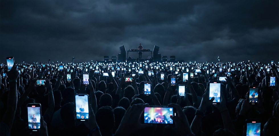 Pessoas assistindo show de música eletrônica com celular na mão