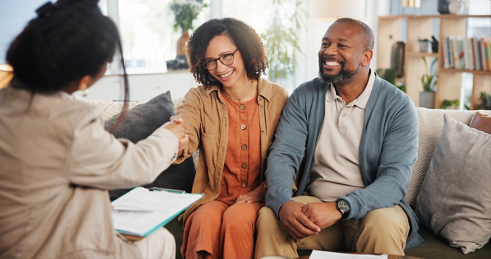 Financial advisor shaking hands with a mature couple at home after discussing life insurance and estate planning.