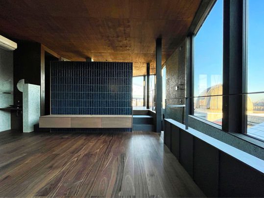 開放的で天井の高いリビング．裏手はダイニングキッチンが緩やかにつながっています．右手は絶景が広がります．