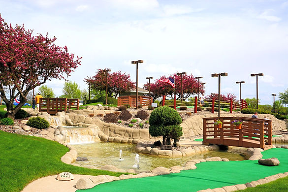 Hole 13, with a water fountain and bridges in the background at the Links Mini Golf Course