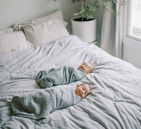 swaddled twins on the bed