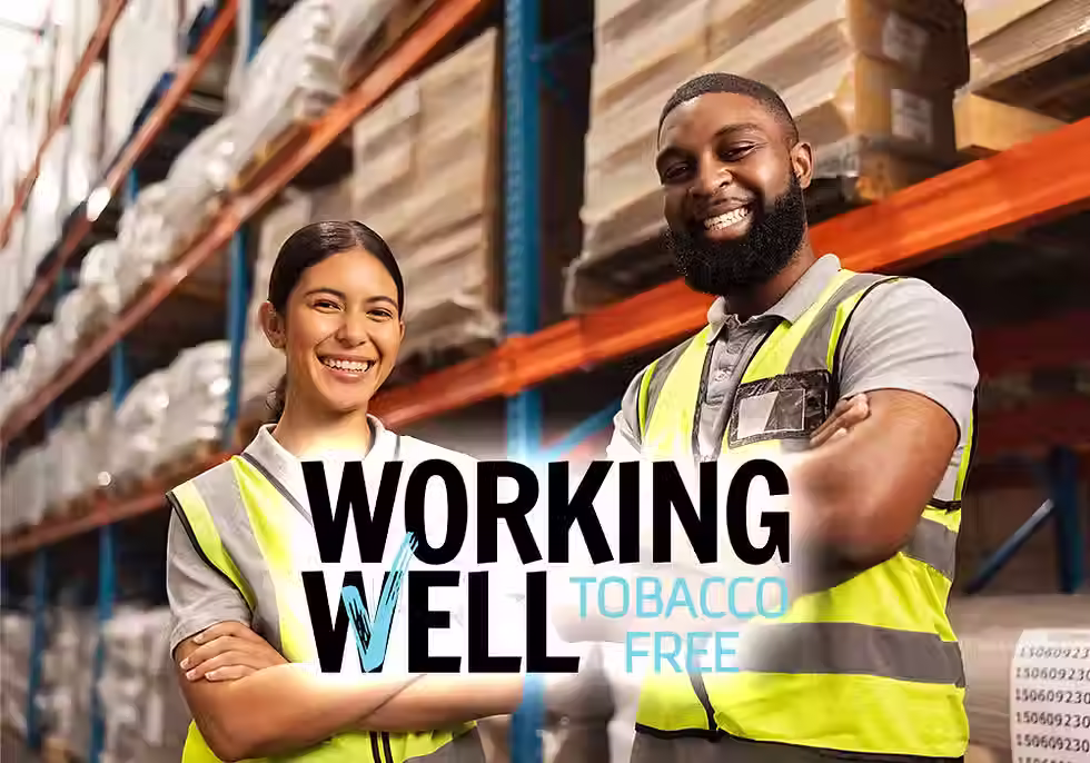 Two warehouse workers standing proudly behind a superimposed Working Well Tobacco Free logo