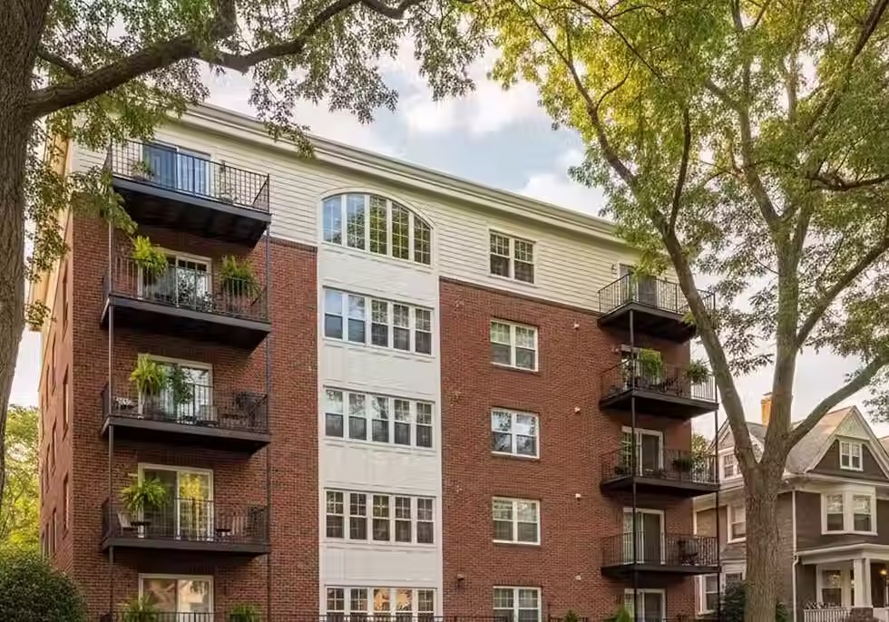 A multi-story apartment building surrounded by trees