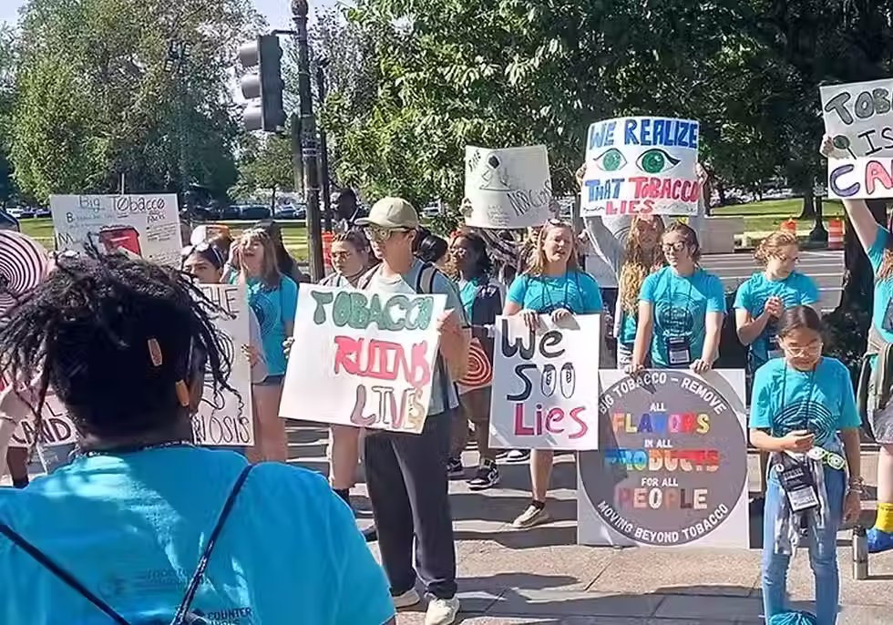 Um grande grupo de pessoas com cartazes feitos à mão para conscientizar sobre o Maio Sem Mentol.
