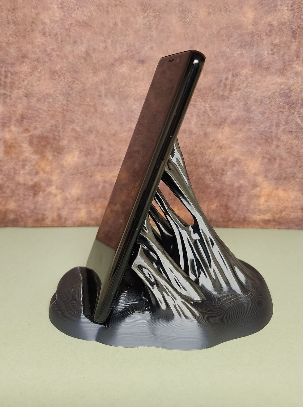 Thumbnail: 3D printed phone stand resembling symbiotic slime holding up your phone